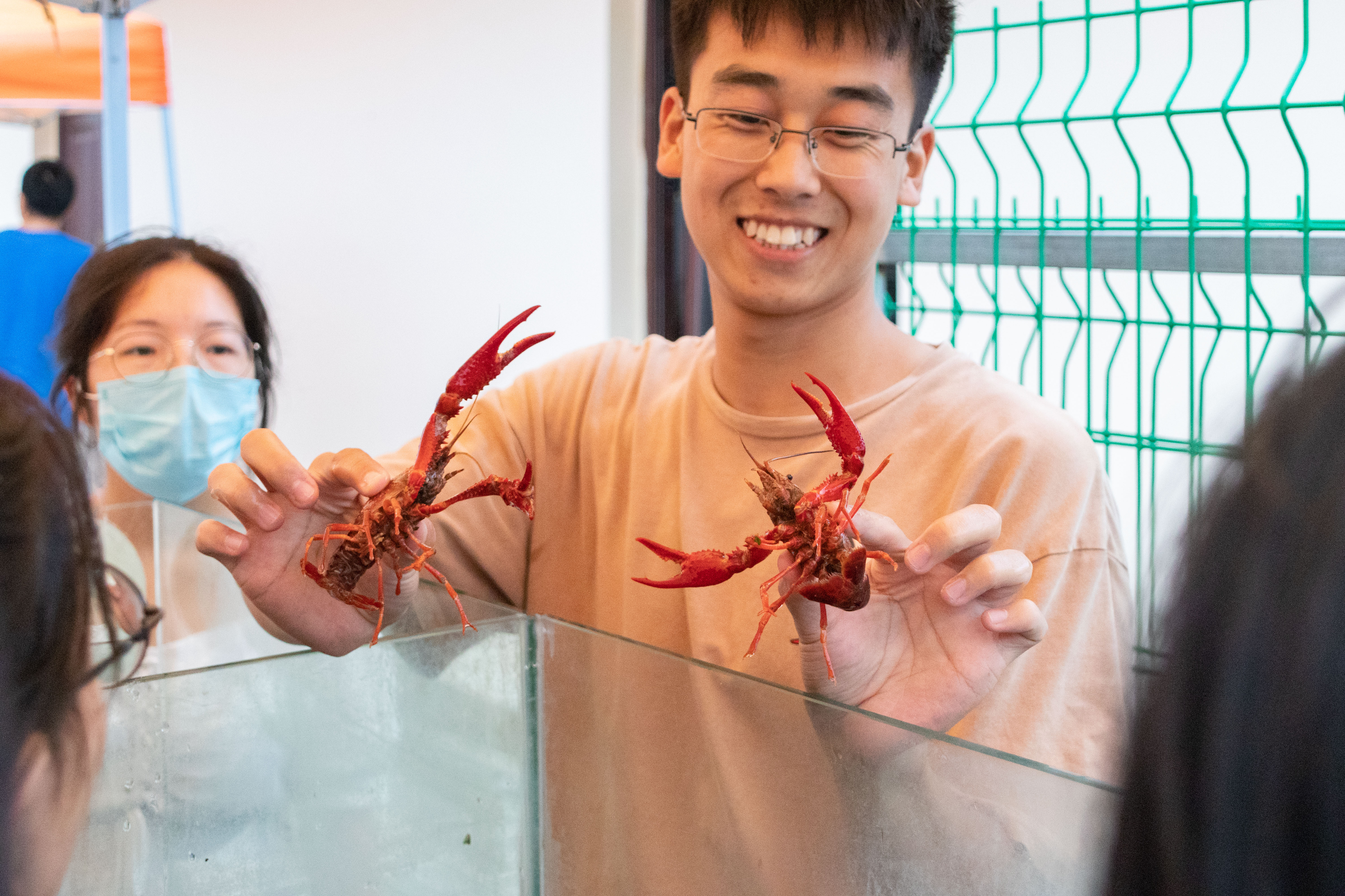 水产学院19级研究生杨伟杰向新生讲解如何辨别小龙虾雌雄（学通社记者 周丹丹 摄）